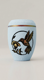 Babyblaue Urne mit Kolibri-Motiv und Blüte in warmen Gold- und Rottönen.