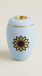 Babyblaue Urne mit goldener Sonnenblume und LED-Teelicht im Deckel.