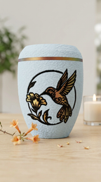 Babyblaue Urne mit Kolibri-Motiv und Blüte in warmen Gold- und Rottönen.